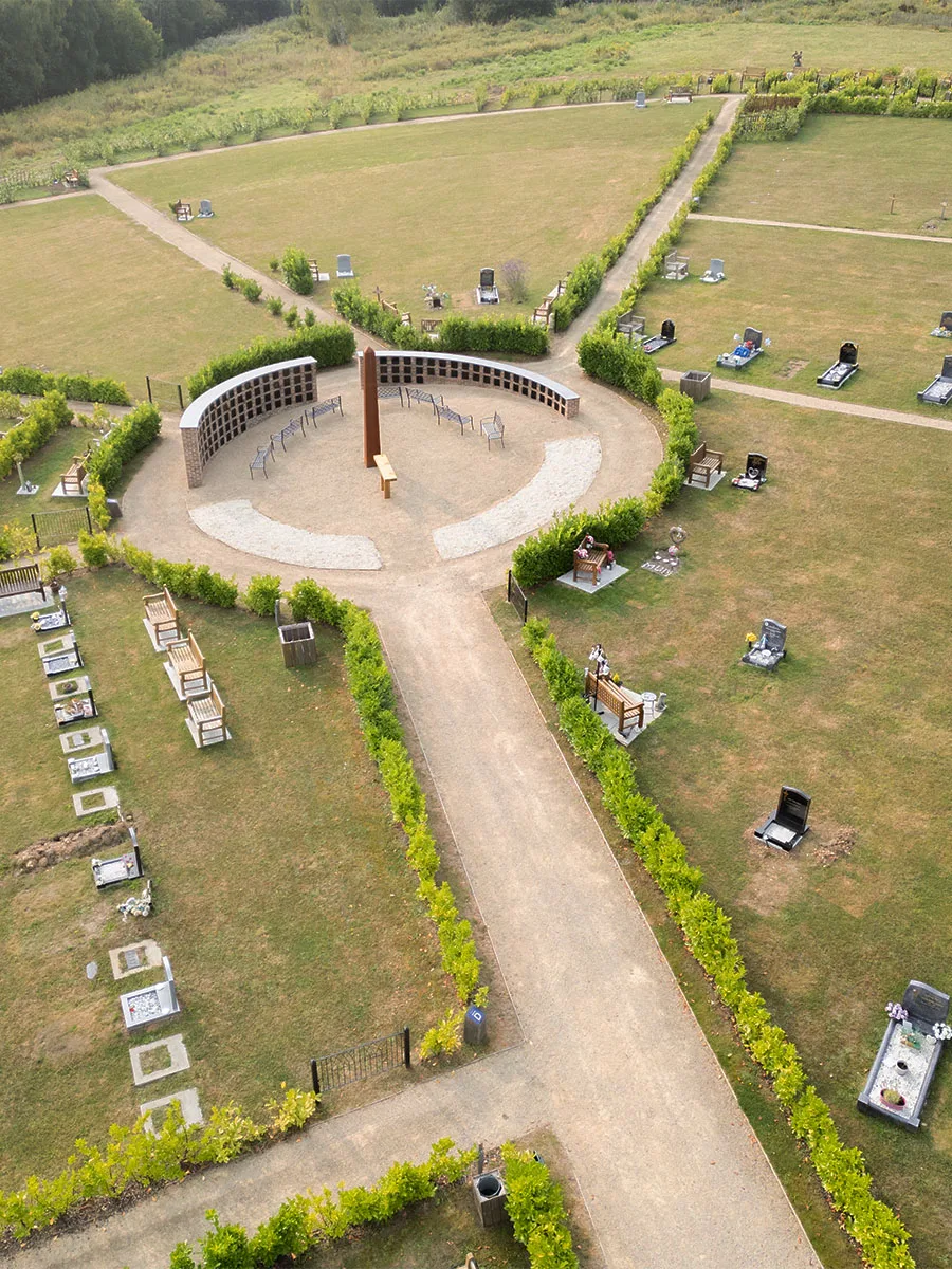 Aerial view of a circular memorial feature where paths meet between lawn burial sections at Bluebell Cemetery