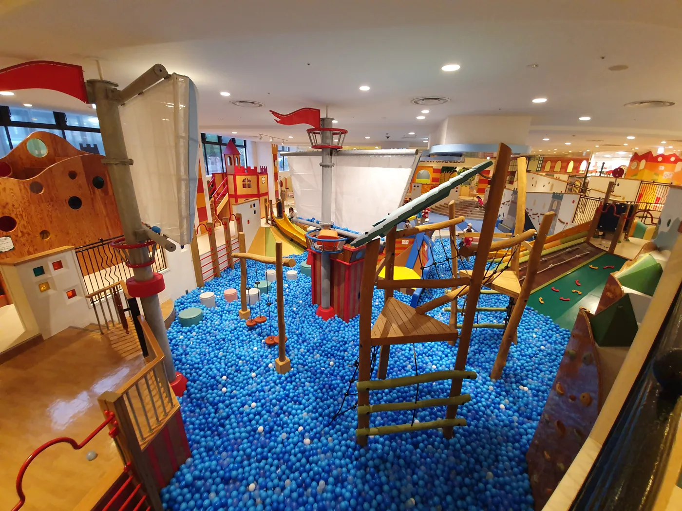 A multi-level indoor play frame and ball pool, photographed at a soft play centre in Tokyo, not one of the Kent venues listed here