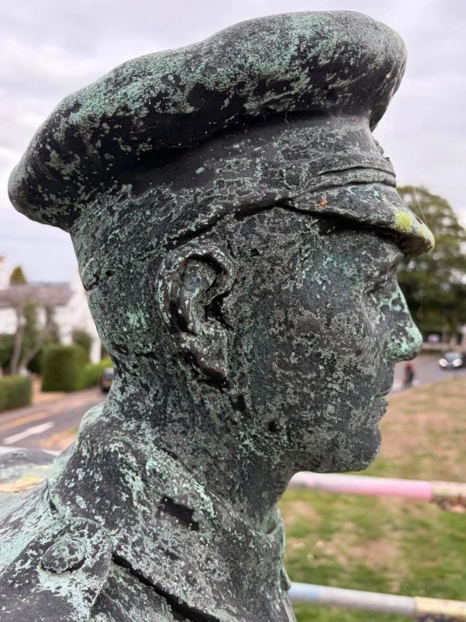 Side view of the soldier's head before treatment, the cap and face mottled with green and black corrosion